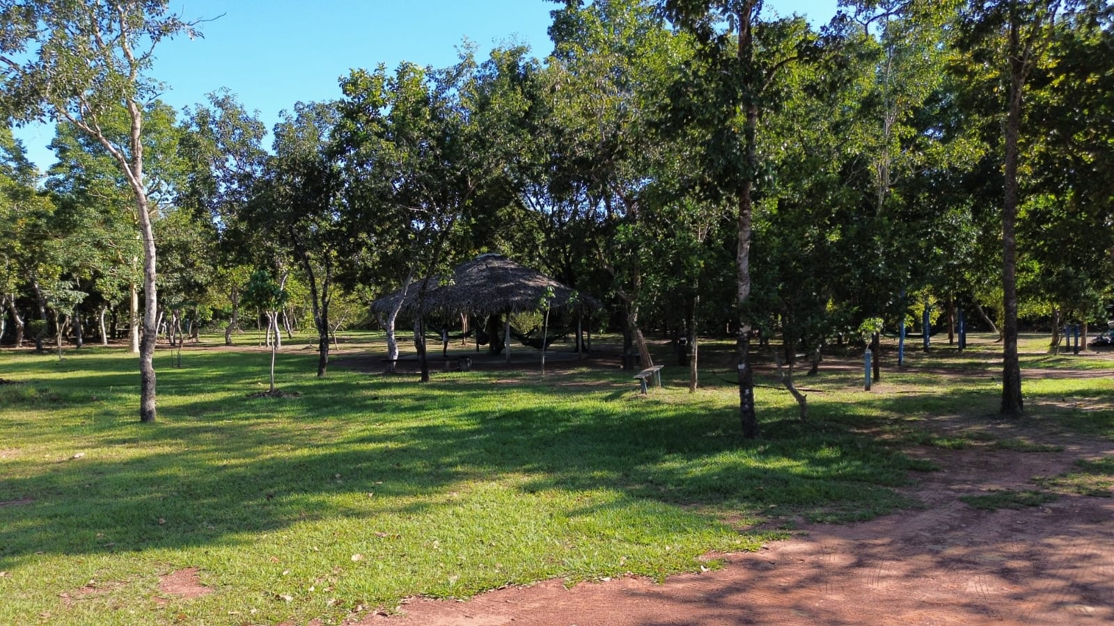 Área gramada e sombreada por árvores no Refúgio das Águas