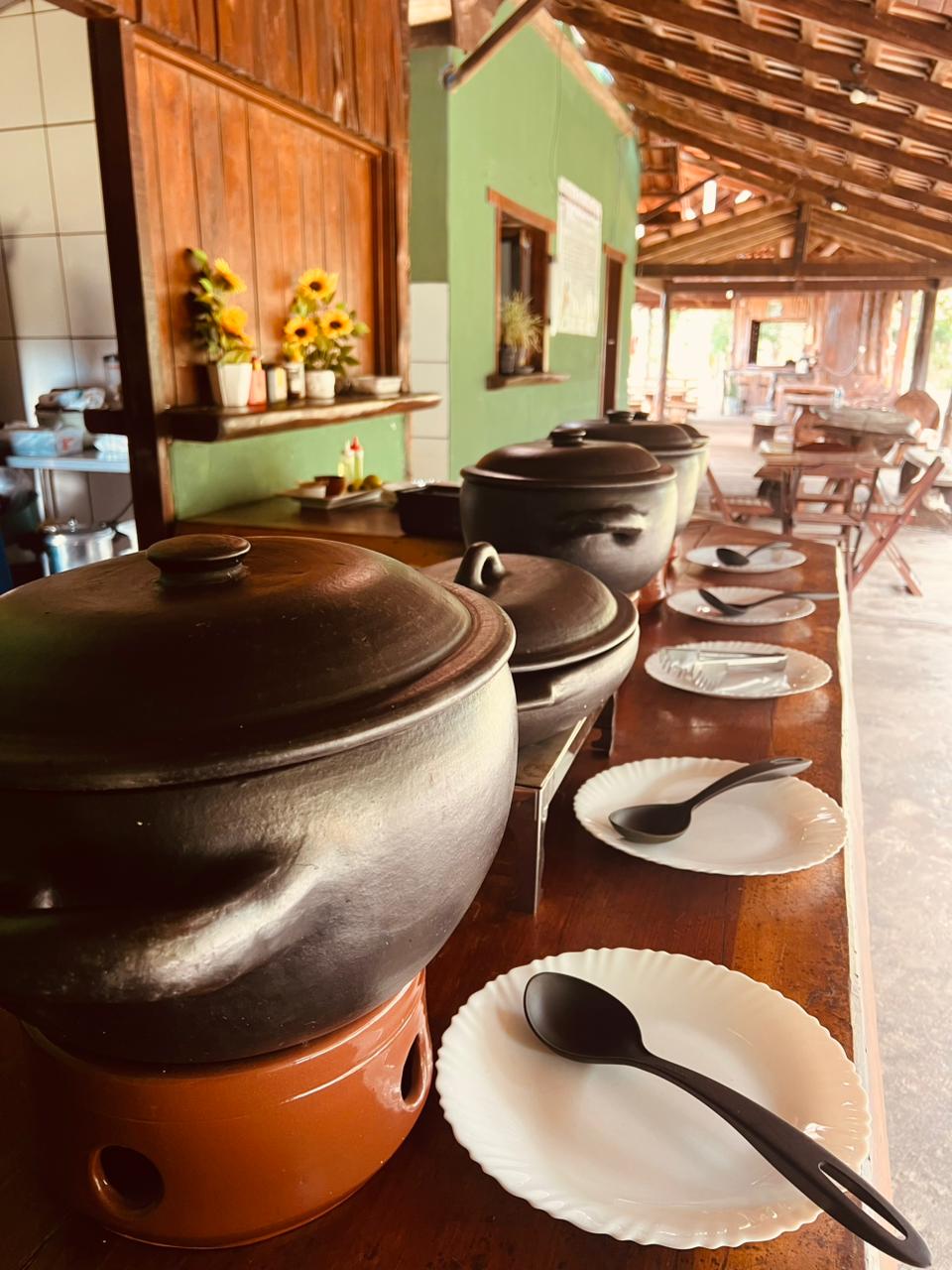 Ambiente do restaurante com panelas de comida caseira no Refúgio das Águas